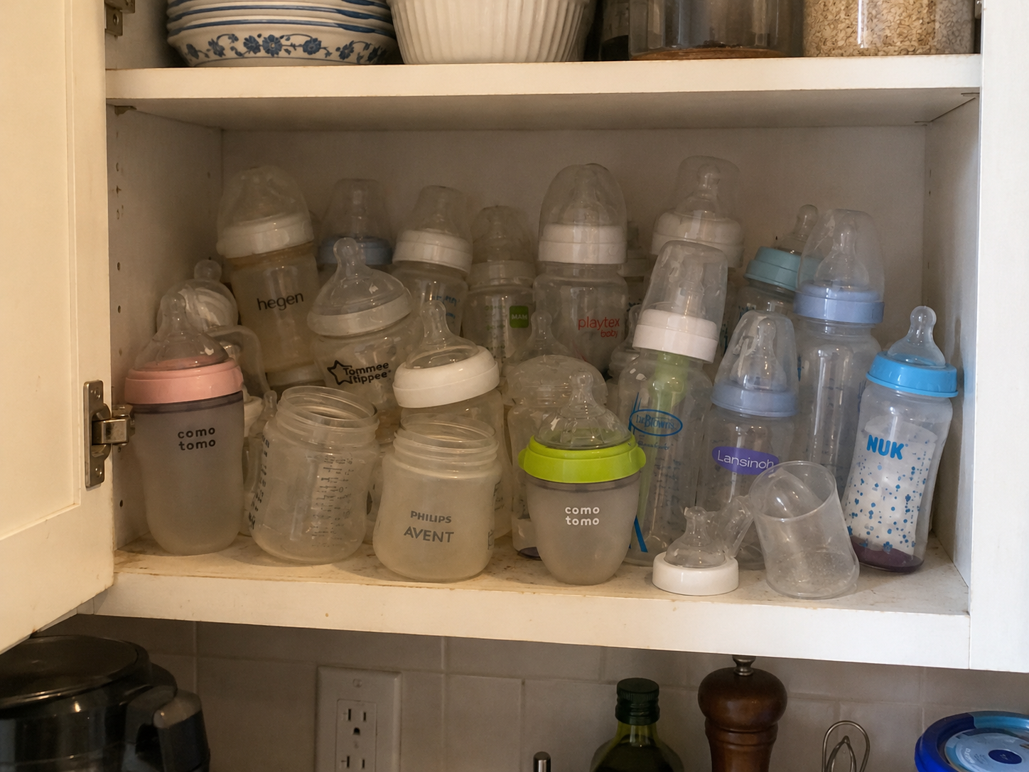 Cupboard full of baby bottles from different anti-colic systems